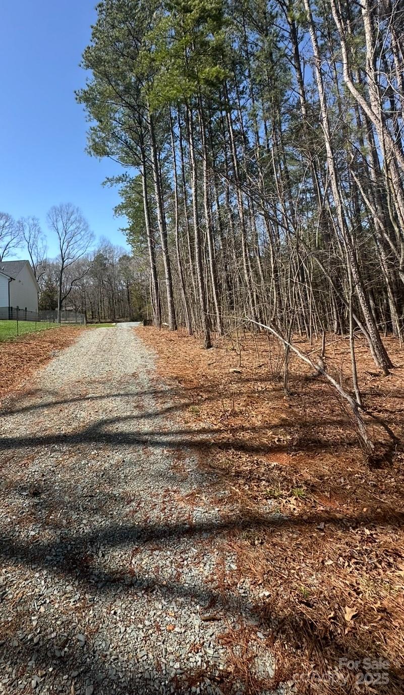 1010 East Sandy Ridge Road, Unit 4 Monroe, NC 28112 - Photo 5 of 15 a view of dirt yard with large trees