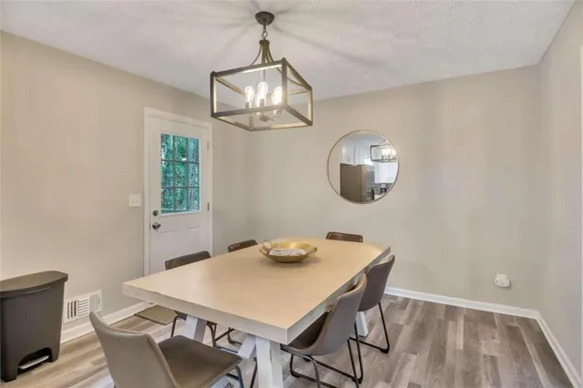a view of a dining room with furniture a chandelier and wooden floor