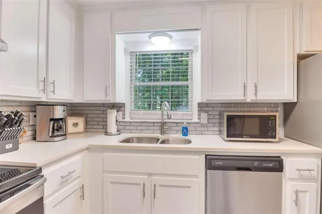 a kitchen with stainless steel appliances white cabinets and a sink