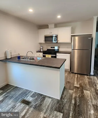 a kitchen with stainless steel appliances granite countertop a sink refrigerator and microwave