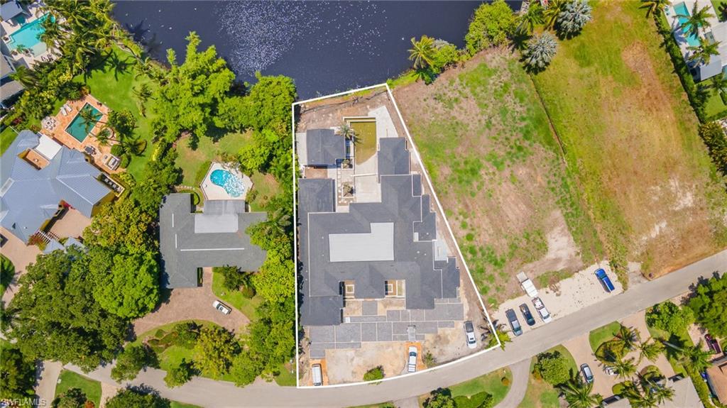 616 Bougainvillea Road Naples, FL 34102 - Photo 18 of 21 Aerial view of property's location featuring a pool area, property boundaries highlighted, and a large body of water