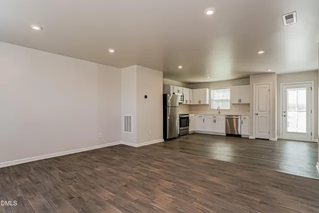 a view of a kitchen with wooden floor and windows
