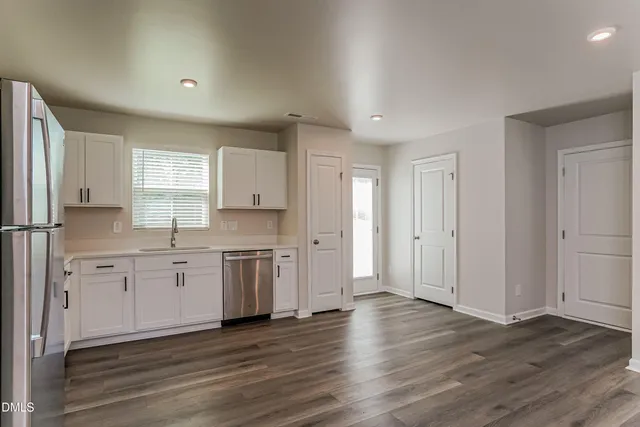a view of a kitchen with a sink a refrigerator and window