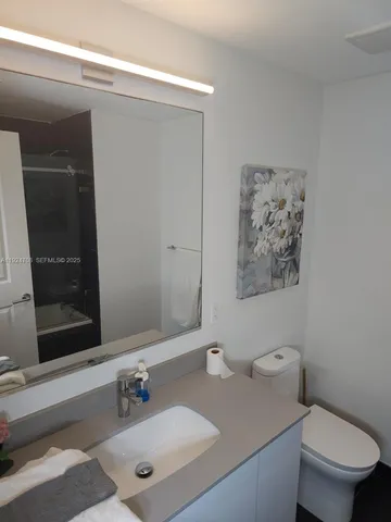 a bathroom with a sink mirror vanity and toilet