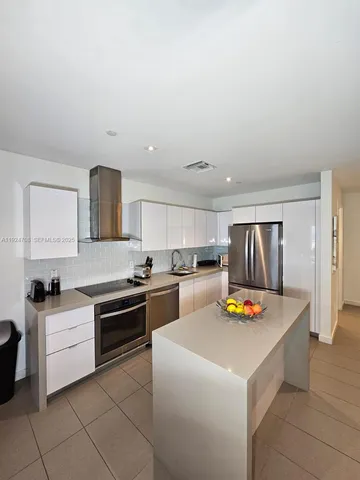 a kitchen with sink refrigerator and stove top oven