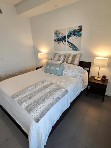 a bedroom with a bed and a night stand