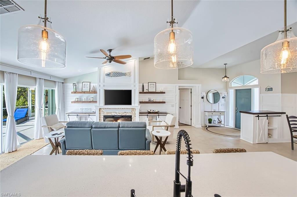 3700 Kent Drive Naples, FL 34112 - Photo 10 of 31 a living room with furniture a flat screen tv and a chandelier