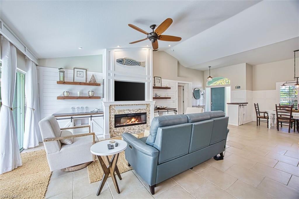 3700 Kent Drive Naples, FL 34112 - Photo 4 of 31 a living room with furniture a flat screen tv and a table