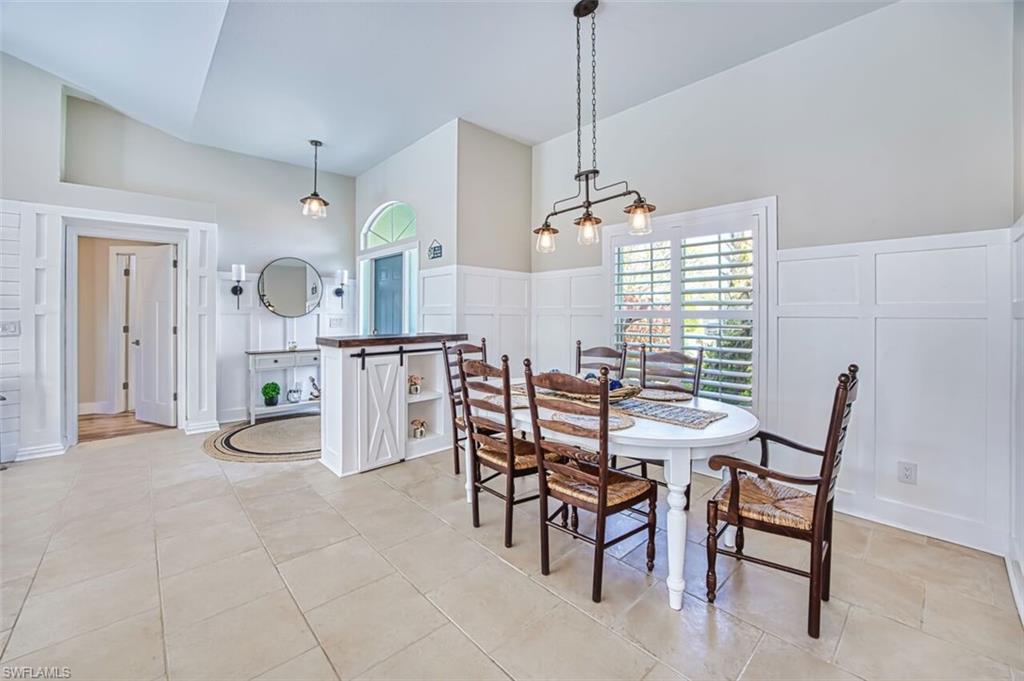 3700 Kent Drive Naples, FL 34112 - Photo 7 of 31 a view of a dining room and livingroom with furniture wooden floor a chandelier
