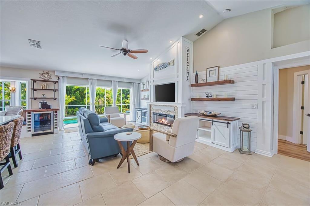 3700 Kent Drive Naples, FL 34112 - Photo 8 of 31 a living room with furniture a fireplace and a flat screen tv