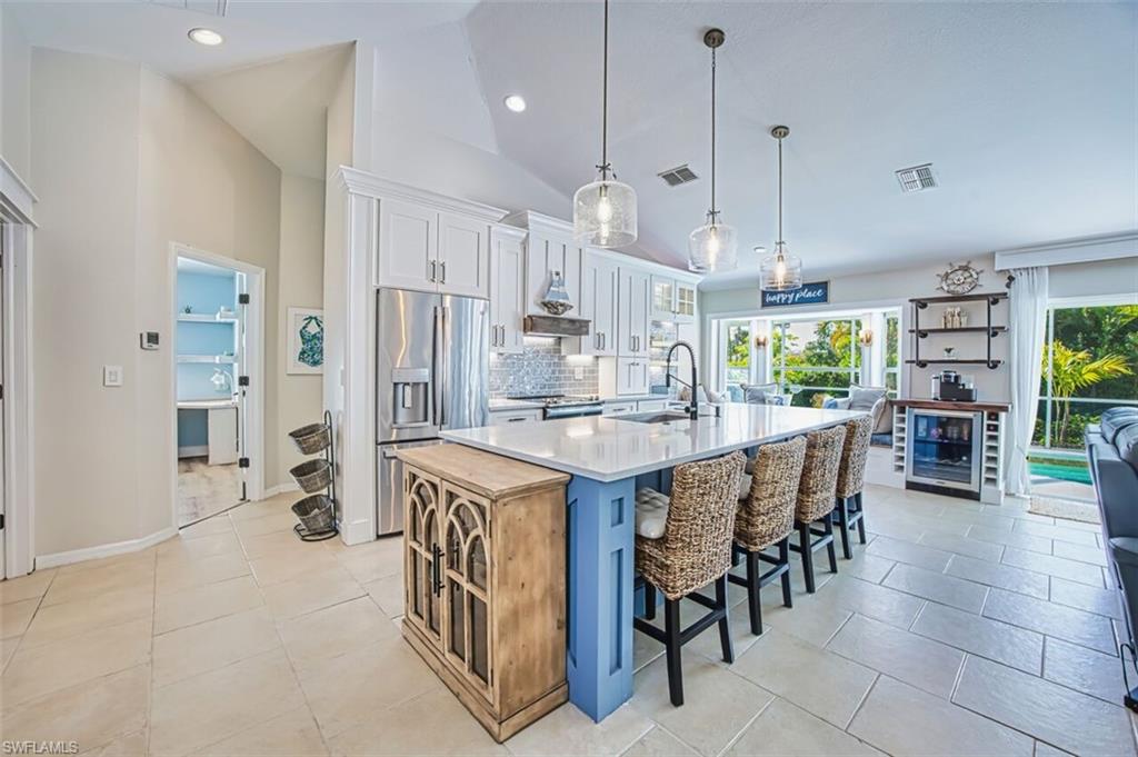 3700 Kent Drive Naples, FL 34112 - Photo 9 of 31 a kitchen with stainless steel appliances kitchen island granite countertop a table chairs and a refrigerator