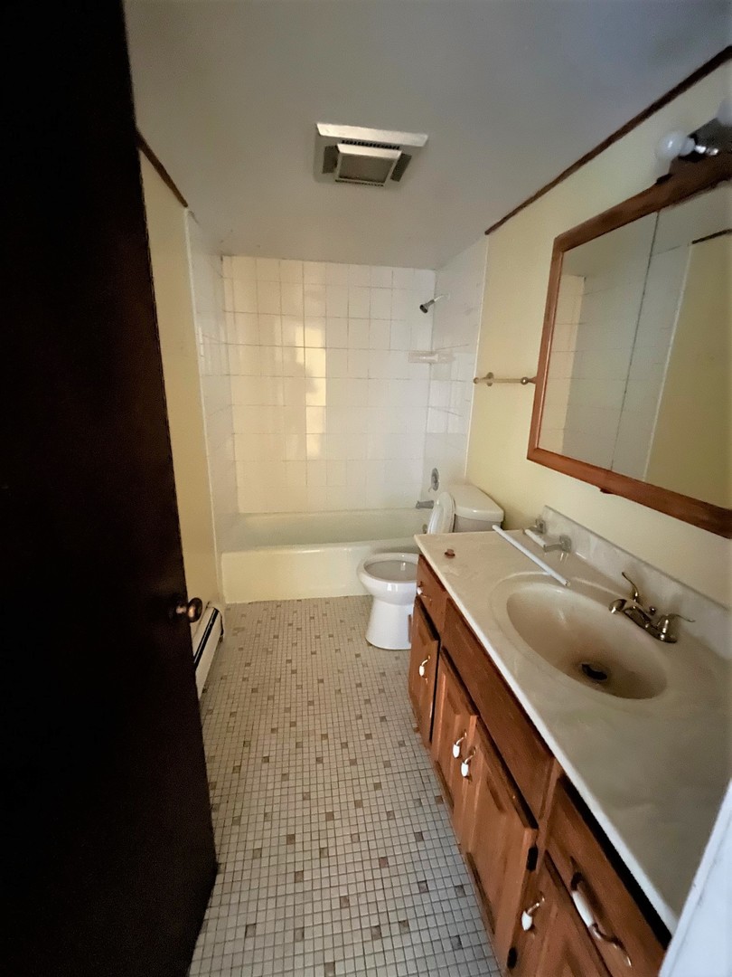 264 East Bailey Road, Unit G Naperville, IL 60565 - Photo 9 of 9 a bathroom with a granite countertop sink a toilet and a mirror