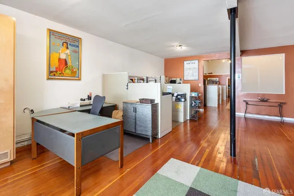 a living room with stainless steel appliances kitchen island granite countertop a stove a refrigerator a dining table and chairs with wooden floor