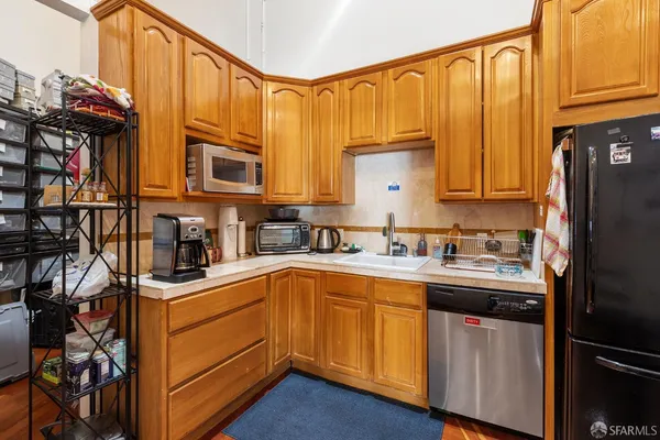 a kitchen with stainless steel appliances granite countertop a refrigerator and a stove top oven