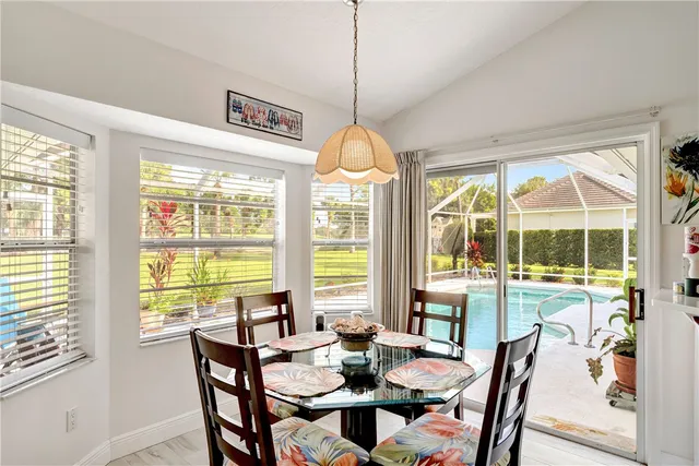 a dining room with furniture large windows and a chandelier