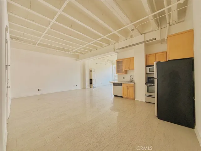 a view of a refrigerator in kitchen and a sink