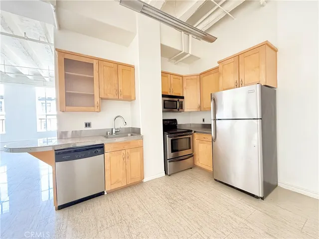a kitchen with granite countertop a refrigerator and a sink
