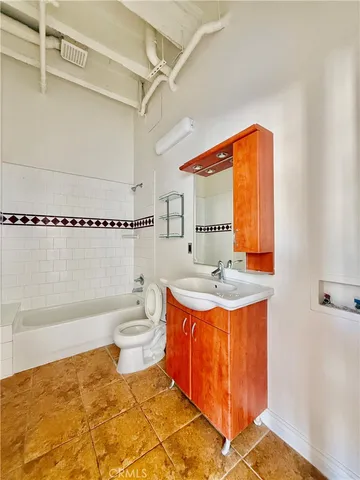 a bathroom with a granite countertop sink a toilet and bathtub