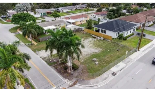 an aerial view of residential houses with outdoor space and trees