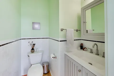 a bathroom with a sink and mirror with toilet