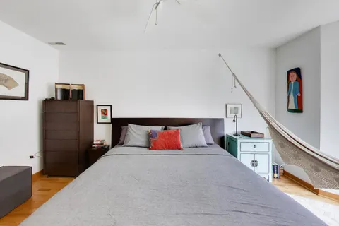 a bedroom with a bed and wooden floor