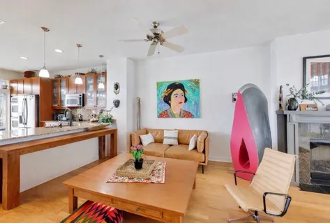 a living room with furniture kitchen view and a chandelier