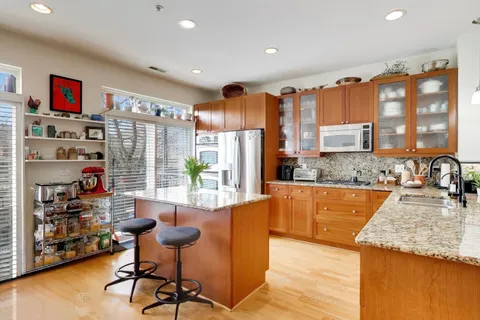 a large kitchen with stainless steel appliances granite countertop a refrigerator and a sink