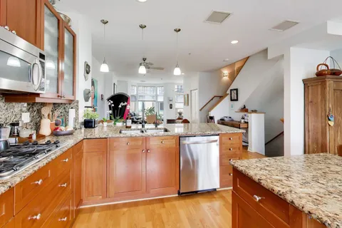 a kitchen with stainless steel appliances granite countertop a sink stove and refrigerator