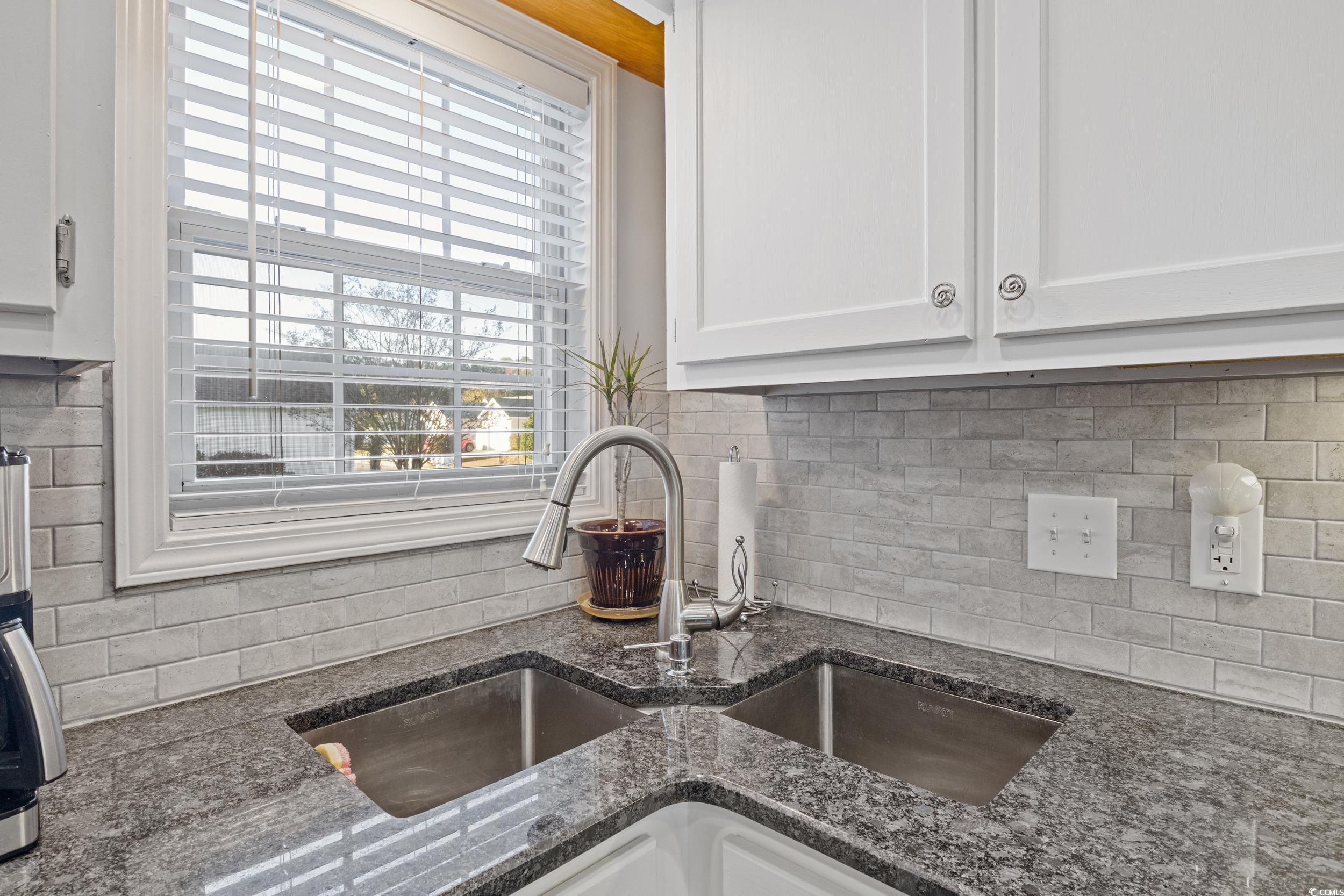 9605 Sullivan Drive Murrells Inlet, SC 29576 - Photo 22 of 40 Kitchen featuring white cabinets, backsplash, sink