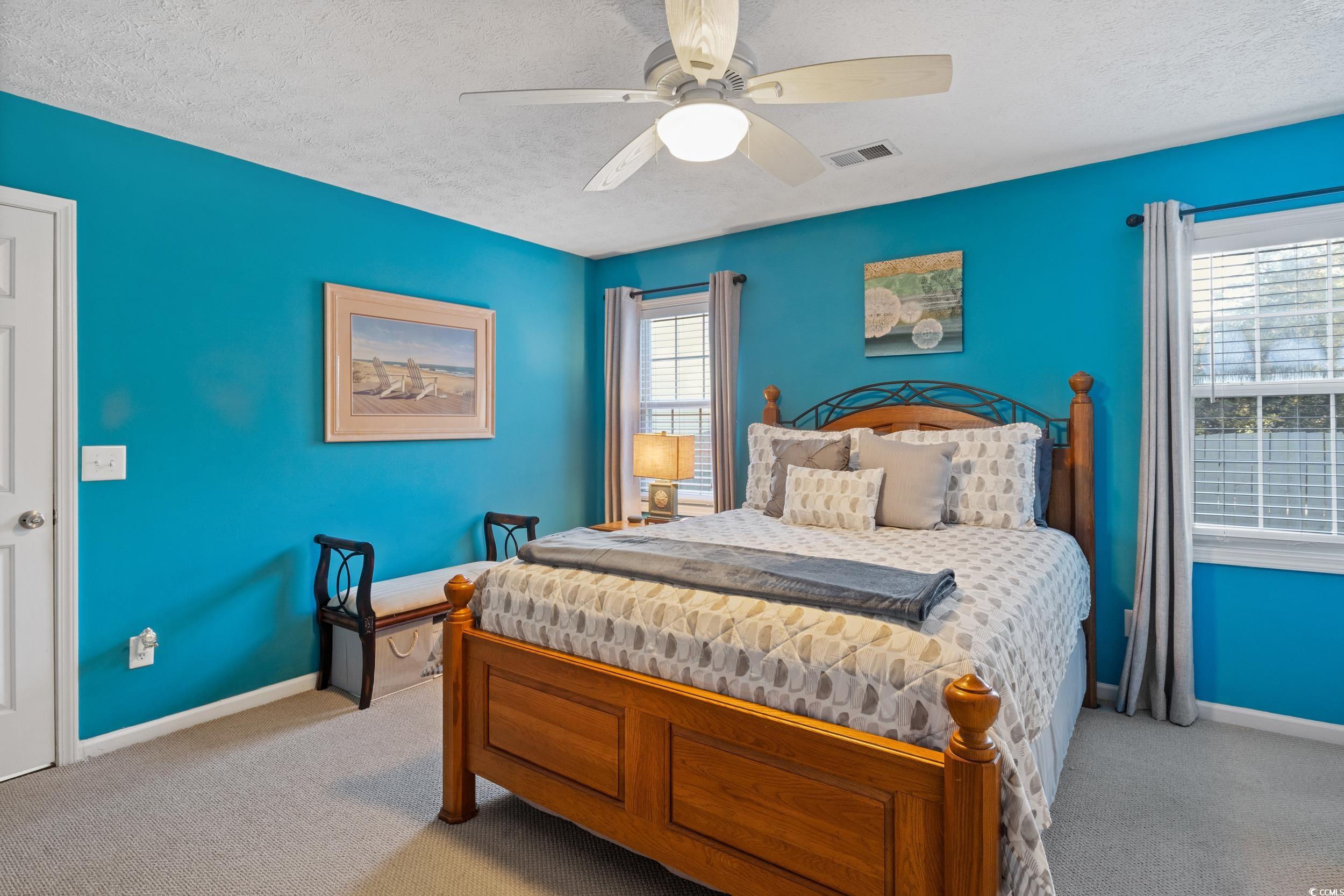 9605 Sullivan Drive Murrells Inlet, SC 29576 - Photo 26 of 40 Carpeted bedroom with ceiling fan and a textured c