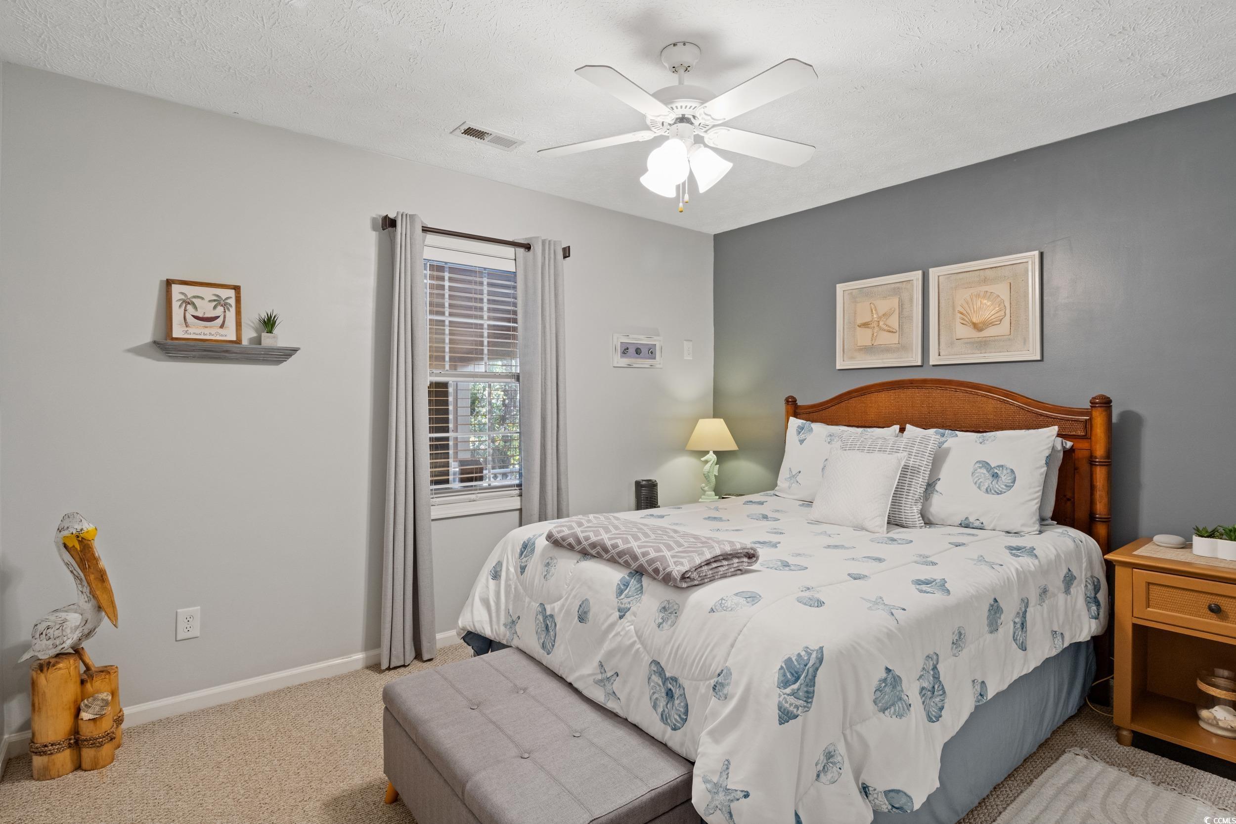 9605 Sullivan Drive Murrells Inlet, SC 29576 - Photo 30 of 40 Bedroom with light carpet, a textured ceiling, and