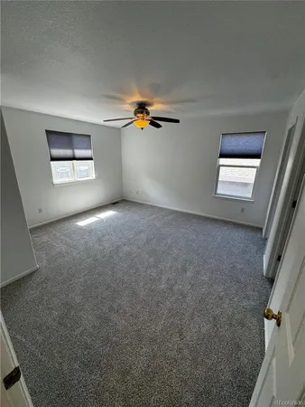 a view of a livingroom with a ceiling fan and window