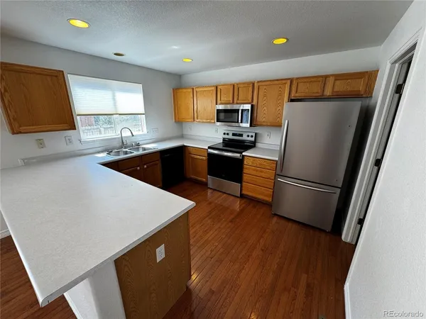 a kitchen with stainless steel appliances a refrigerator a sink a stove a microwave a counter top and cabinets