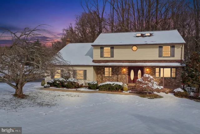 a front view of a building with lots of green space and bench