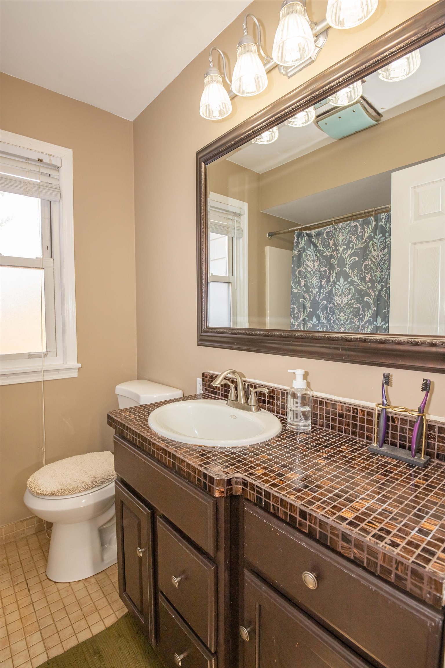 3808 Highcrest Road Rockford, IL 61107 - Photo 24 of 34 a bathroom with a granite countertop sink a toilet and a mirror