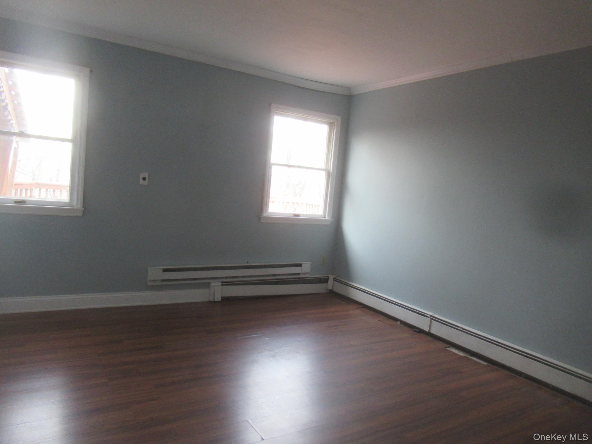 64 Hillside View Road Mahopac, NY 10541 - Photo 15 of 25 Empty room with ornamental molding, a baseboard radiator, dark wood-type flooring, and baseboard heating
