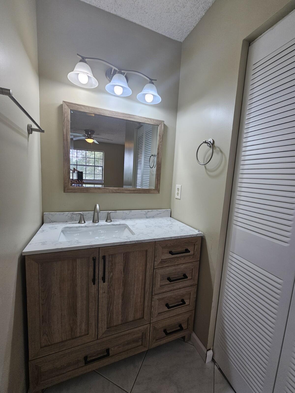 3150 Leewood Terrace, Unit L222 Boca Raton, FL 33431 - Photo 14 of 39 a bathroom with a sink and a mirror