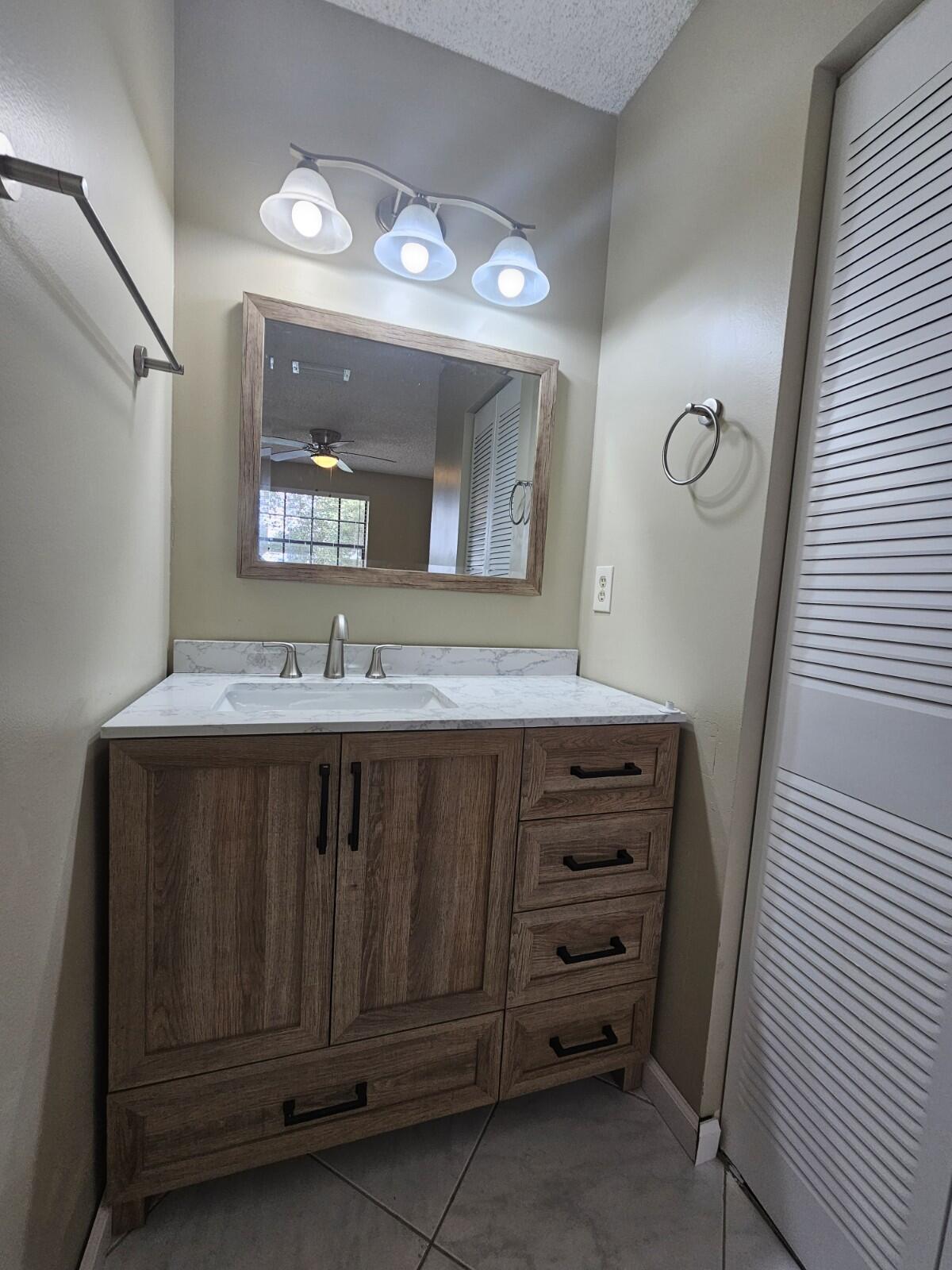 3150 Leewood Terrace, Unit L222 Boca Raton, FL 33431 - Photo 15 of 39 a bathroom with a sink vanity and mirror