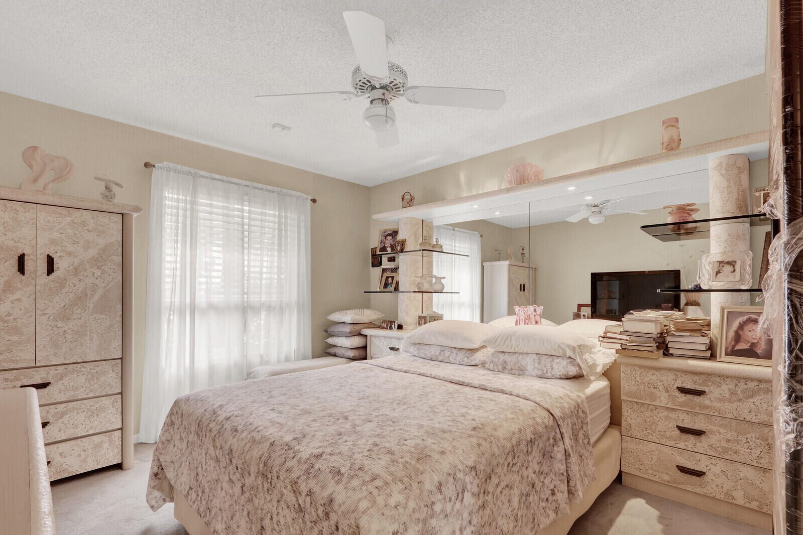352 River Edge Road Jupiter, FL 33477 - Photo 42 of 50 a spacious bedroom with a bed a dresser and a chandelier