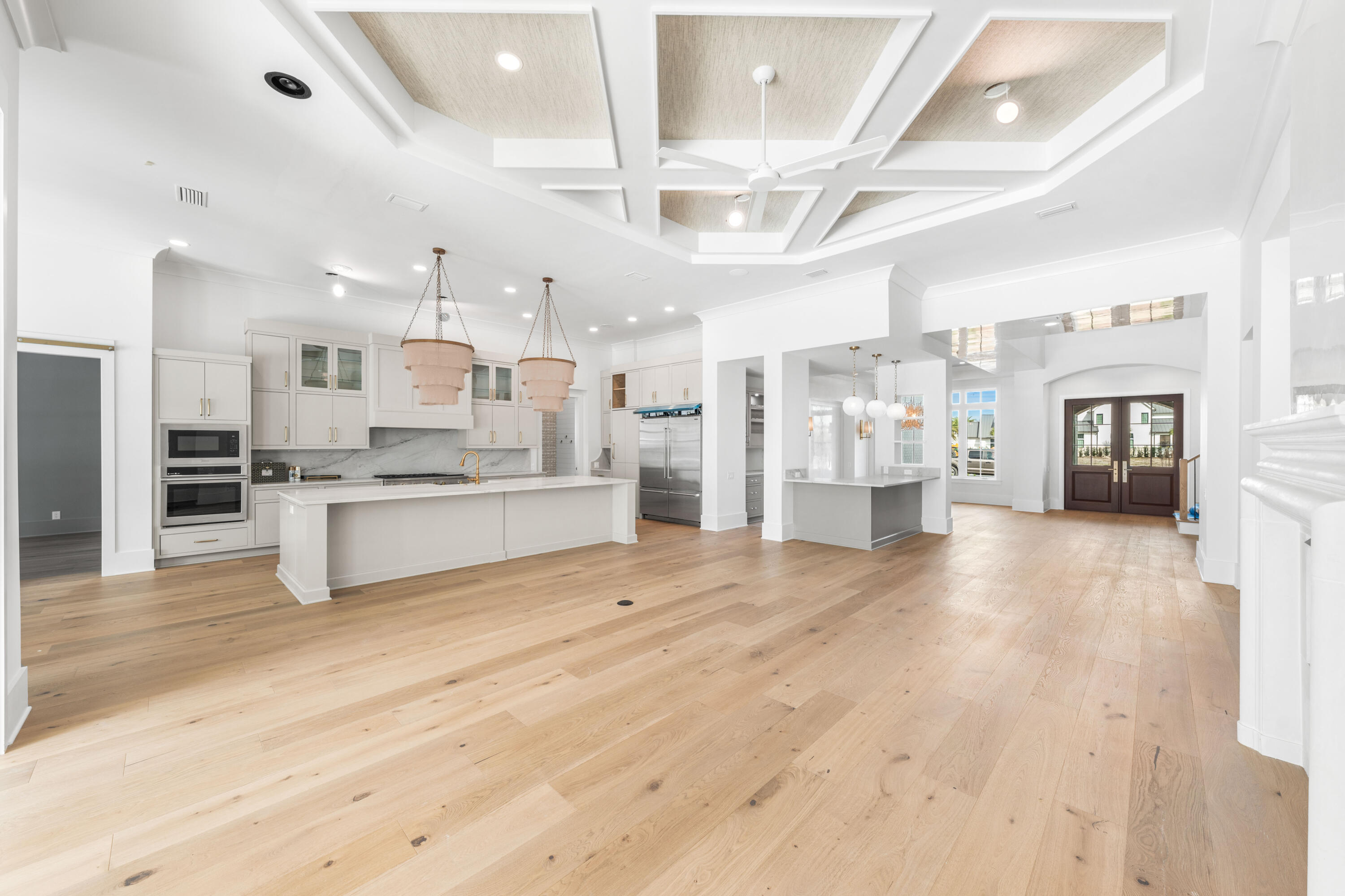 303 Golfridge Drive Watersound, FL 32461 - Photo 13 of 50 a large white kitchen with stainless steel appliances kitchen island granite countertop a large counter top and view living room