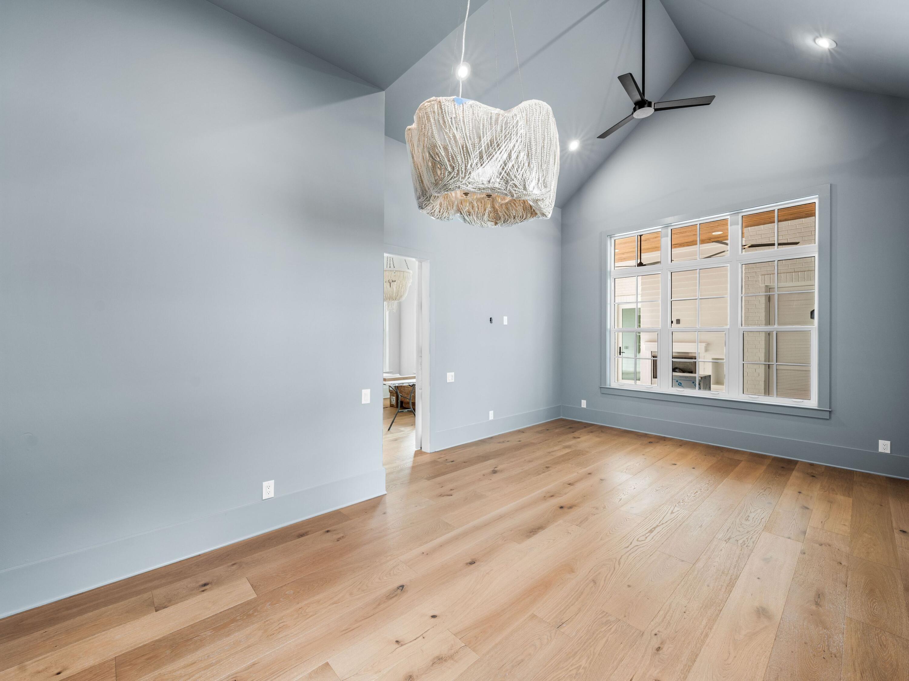 303 Golfridge Drive Watersound, FL 32461 - Photo 14 of 50 en empty room with wooden floor and windows