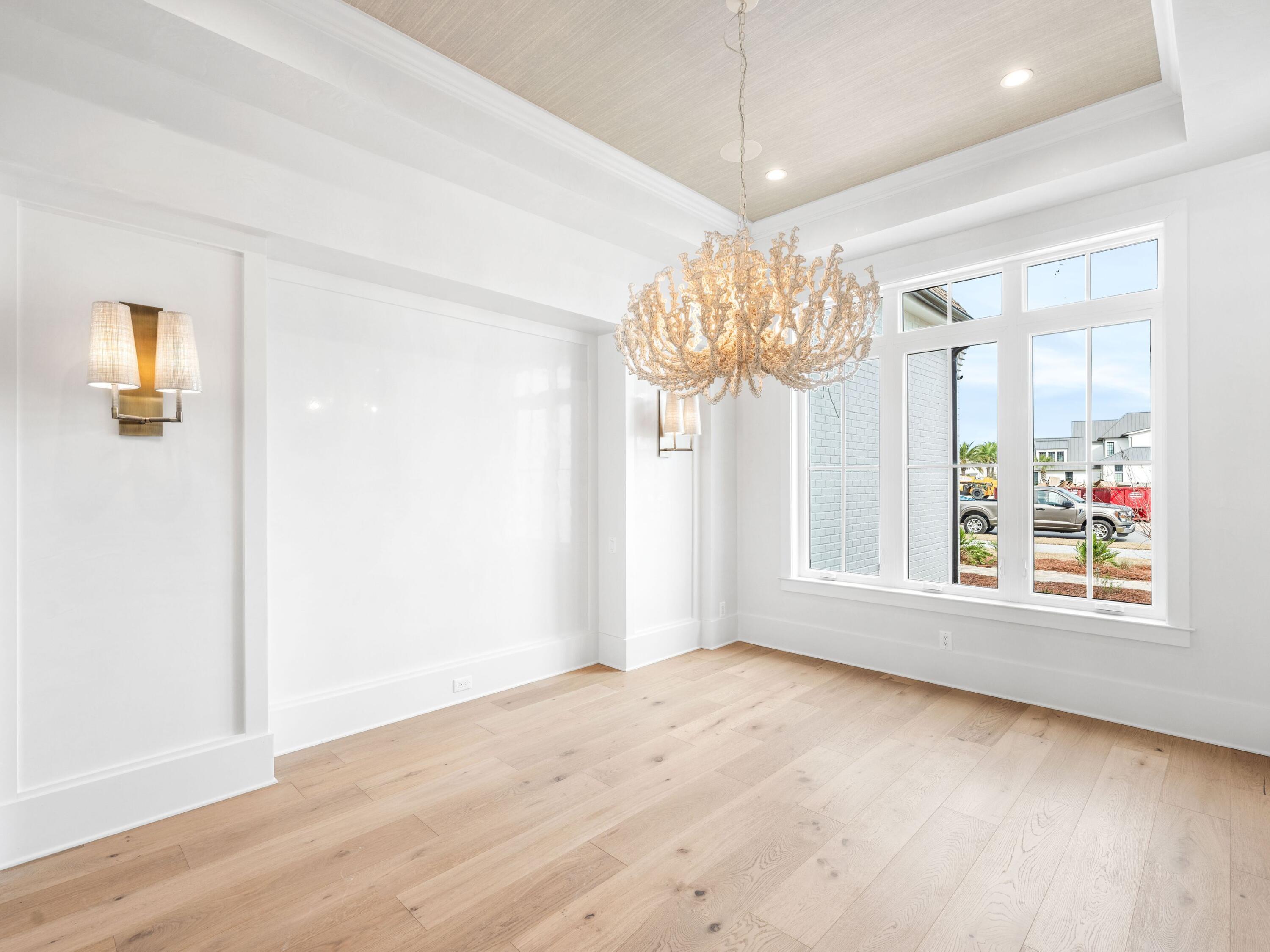 303 Golfridge Drive Watersound, FL 32461 - Photo 18 of 50 an empty room with wooden floor chandelier and windows
