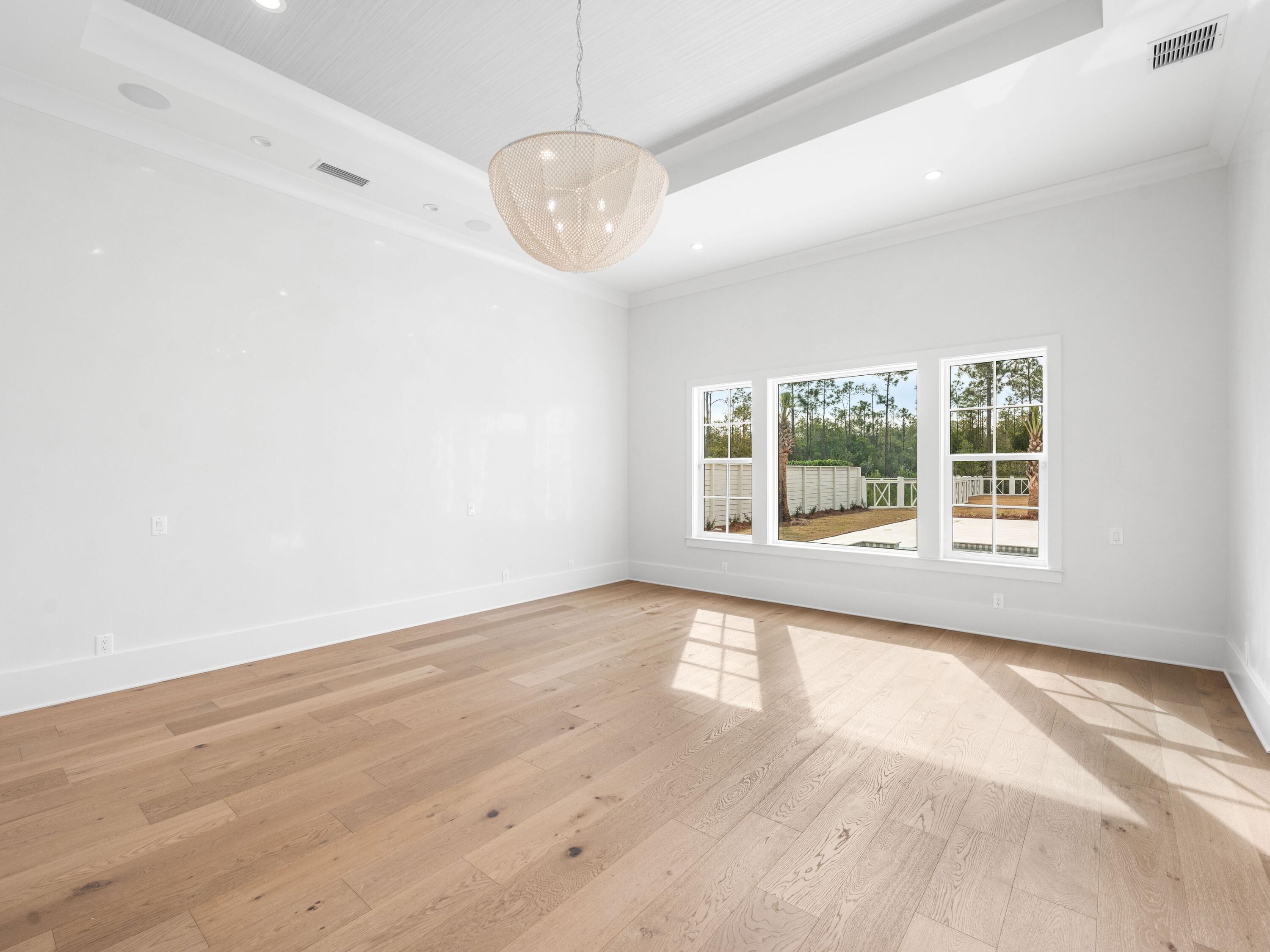 303 Golfridge Drive Watersound, FL 32461 - Photo 21 of 50 a view of an empty room with wooden floor and a window