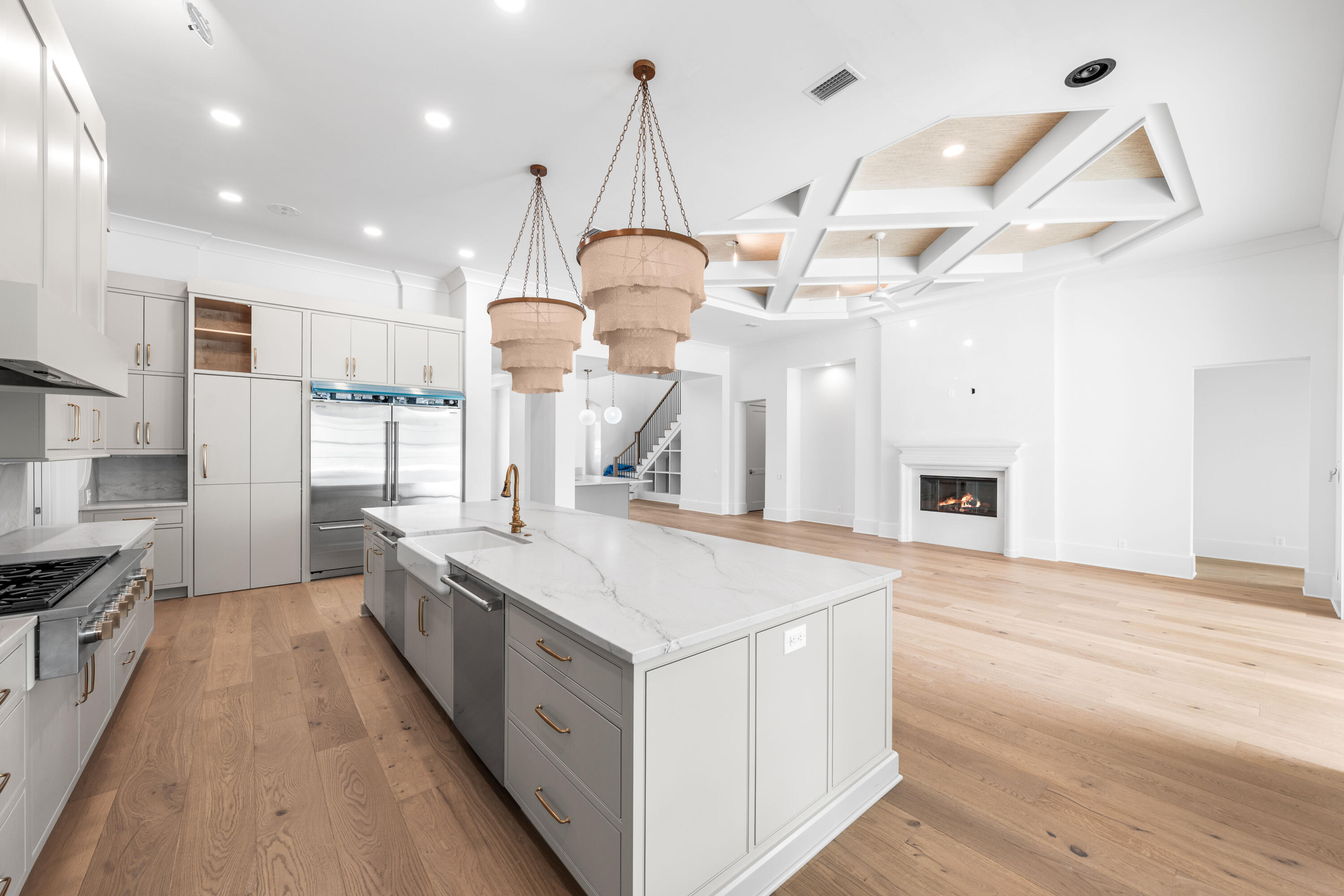 303 Golfridge Drive Watersound, FL 32461 - Photo 10 of 50 a large kitchen with kitchen island a stove a sink a center island and wooden floor