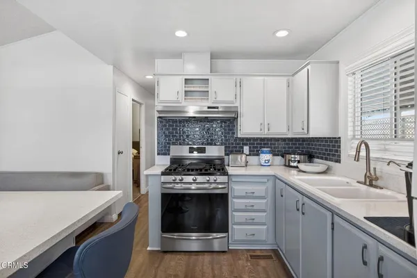 a kitchen with a stove sink and cabinets