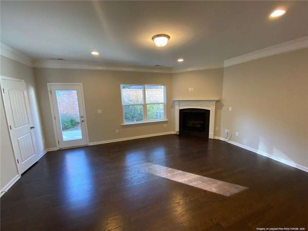 1206 Wingstem Place Raleigh, NC 27607 - Photo 12 of 17 an empty room with wooden floor fireplace and windows