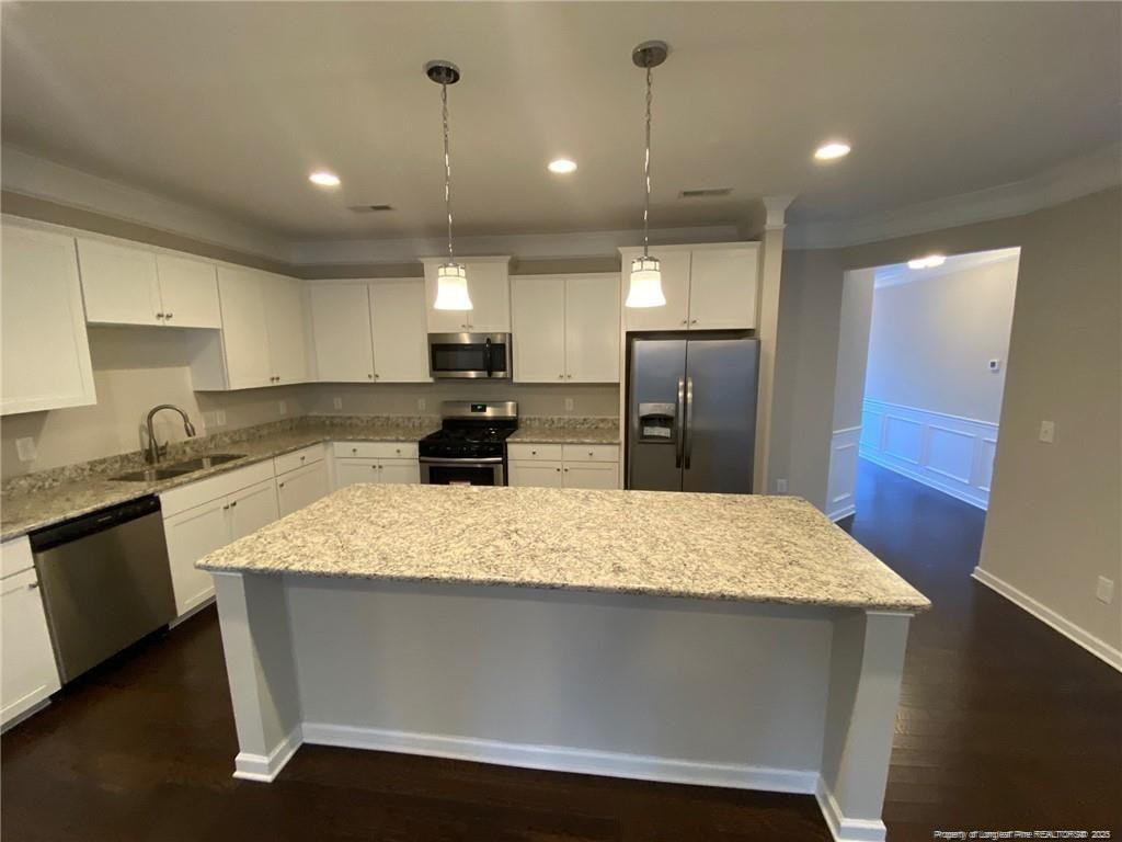 1206 Wingstem Place Raleigh, NC 27607 - Photo 17 of 17 a large kitchen with kitchen island a sink stainless steel appliances and cabinets