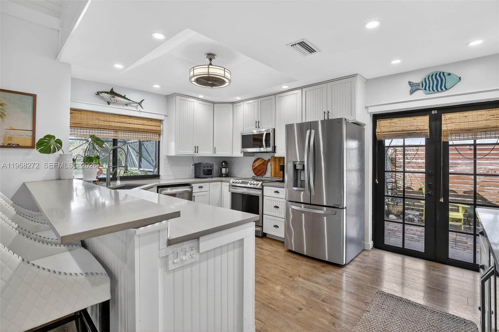 8740 Southwest 56th Place Cooper City, FL 33328 - Photo 11 of 54 a kitchen with stainless steel appliances granite countertop a refrigerator a sink a stove and a refrigerator with wooden floor