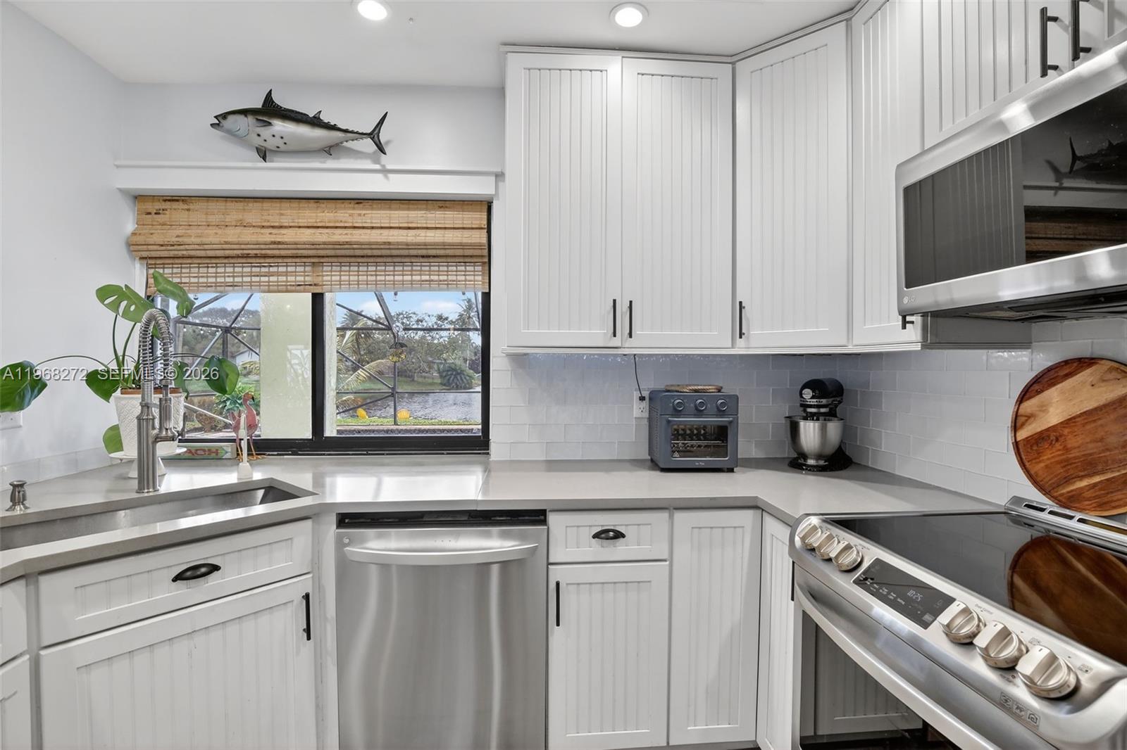 8740 Southwest 56th Place Cooper City, FL 33328 - Photo 13 of 54 a kitchen with stainless steel appliances granite countertop a stove and a white cabinets