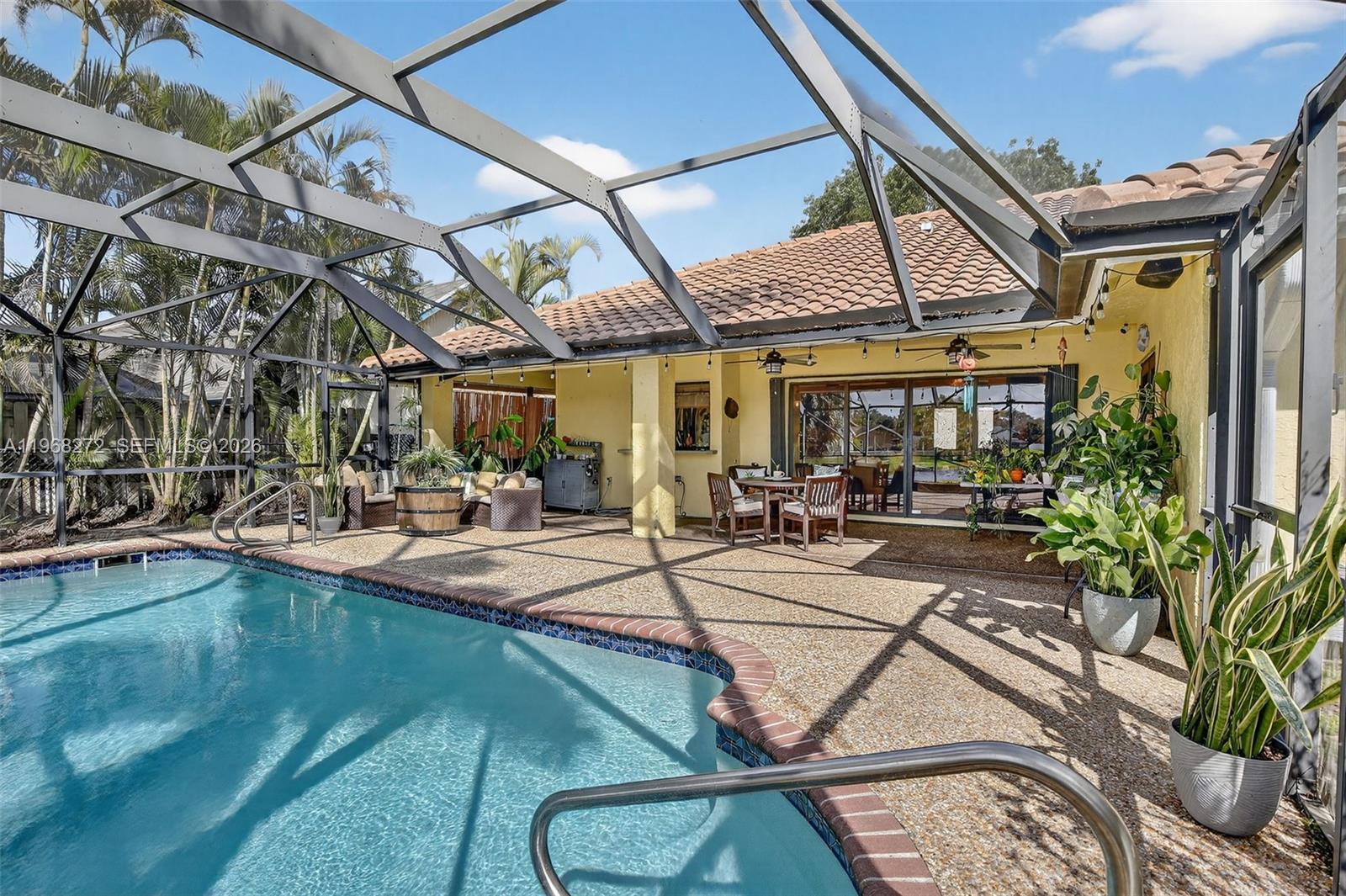 8740 Southwest 56th Place Cooper City, FL 33328 - Photo 18 of 54 a view of a patio with table and chairs potted plants with floor to ceiling window and potted plants